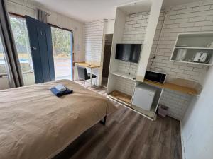 Zimmer mit einem Bett, einer Küche und einem TV in der Unterkunft Mayfield Motel in Mayfield