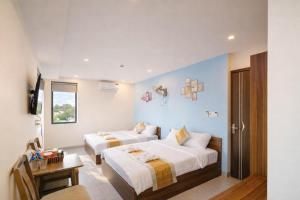 ein Hotelzimmer mit zwei Betten und einem Fenster in der Unterkunft Như Ý Hotel Tây Ninh in Tây Ninh