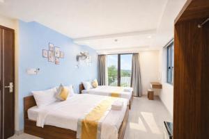 ein Hotelzimmer mit zwei Betten und einem Fenster in der Unterkunft Như Ý Hotel Tây Ninh in Tây Ninh