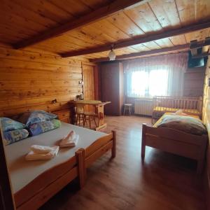una camera con 2 letti in una baita di tronchi di Biesiada a Czarna Góra