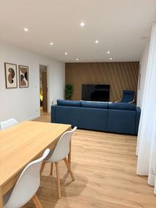 een woonkamer met een tafel en een blauwe bank bij L élégance centre historique Dole 70 m2 in Dole