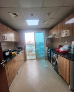 eine Küche mit Waschmaschine und Trockner in der Unterkunft City Lights holiday home in Ajman 