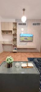 ein Wohnzimmer mit Tisch und Fernseher in der Unterkunft City Lights holiday home in Ajman 