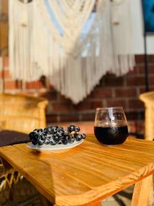 a glass of wine and a plate of black olives on a wooden table at Kali Hideaway Experience Arusha in Arusha