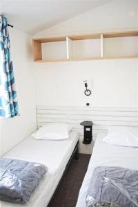 two twin beds in a room at ZEcamping 4 avec pet friendly piscine couverte à 200m de la plage in Plomodiern