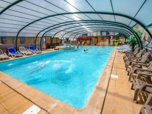 ein großes Schwimmbecken mit Liegestühlen und ein Indoor-Schwimmbadspiegel in der Unterkunft Camping 4 étoiles - Piscine - ccbegca in Créach-Guennou