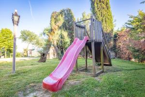 a playground with a pink slide in a park at Agriturismo La Querciola in Riolo Terme