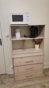 un micro-ondes posé sur une commode en bois dans l'établissement Studio mignon en plein centre de Vichy, à La Celle-sous-Gouzon