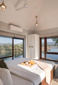 a bedroom with a large bed and large windows at SaffronStays La Mia Casa in Jāmb +76 photos