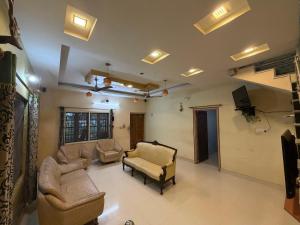 een grote woonkamer met banken en een televisie bij Lakefront Villa in Manipala