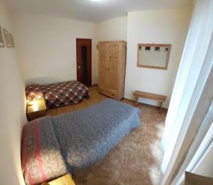 a bedroom with a bed and a dresser in it at Appartamento IN CENTRO a Predazzo in Predazzo +6 photos