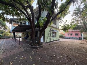 een boom voor een gebouw met een overkapping bij Lakefront Villa in Manipala