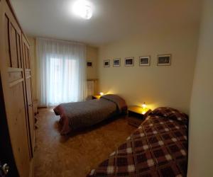 a bedroom with two beds and a window at Appartamento IN CENTRO a Predazzo in Predazzo