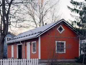 una casa rossa con una recinzione bianca davanti di Guest House Salo-City a Salo