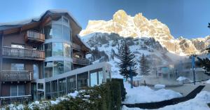 洛伊克巴德维多利亚洛伊克巴德温泉酒店的山前的积雪建筑