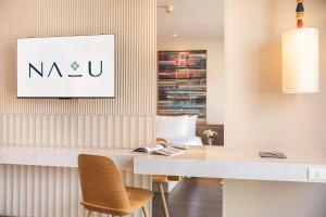 a dining room with a white table and chairs at Na U Hotel in Chiang Mai