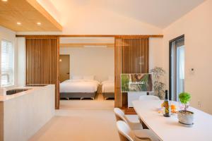 a kitchen and a living room with a table and chairs at Hold in Hamdeok with Pool in Jeju +143 photos