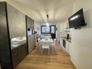 een keuken en eetkamer met een tafel en stoelen bij La Casa di Paolo - Monolocale ristrutturato con vista sulle montagne in Caspoggio