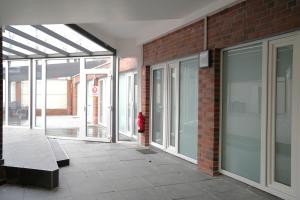 a brick building with sliding glass doors and a fire hydrant at Hotel am Schürblick in Gronau
