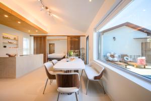 a room with a table and chairs and a window at Hold in Hamdeok with Pool in Jeju