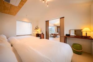 a bedroom with a white bed and a television at Hold in Hamdeok with Pool in Jeju