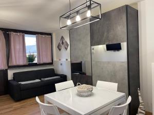 een woonkamer met een witte tafel en een bank bij La Casa di Paolo - Monolocale ristrutturato con vista sulle montagne in Caspoggio
