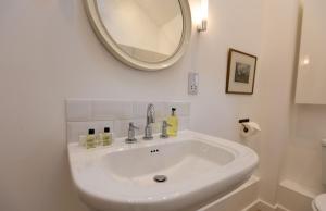 un lavandino bianco in un bagno con uno specchio di Kerry House a Deddington Altre 19 foto