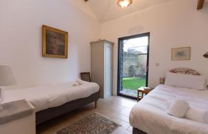 una camera da letto con due letti e una grande finestra di Kerry House a Deddington