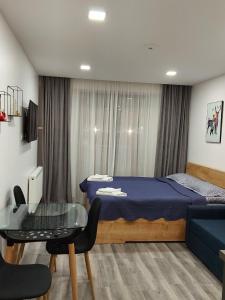 een slaapkamer met een blauw bed en een glazen tafel bij New gudauri loft 1 - #434 in Goedaoeri