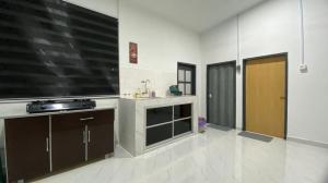 a large kitchen with a large tv on the wall at Marang Private Pool Homestay - 3-Bedroom - Family & Group Stay in Marang