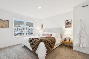 een witte slaapkamer met een bed en een raam bij The Wonder 