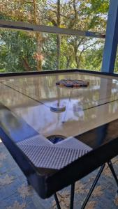 een glazen tafel met een stoel voor een raam bij Archana Resorts in Madikeri