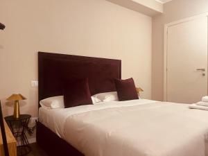 a bedroom with a large white bed with brown pillows at Gatto Bianco Carulli in Bari