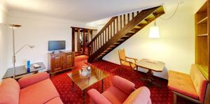 uma sala de estar com um sofá e uma escada em DAS LUDWIG Sports Resort em Bad Griesbach