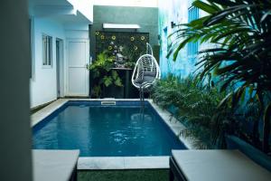 a swimming pool in the middle of a room with plants at Onzo Yamy in Luanda