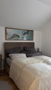 a bedroom with a bed with a painting above it at Vrdnik Residence - Apartmani Anonim in Vrdnik