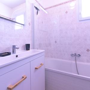 ein weißes Badezimmer mit Waschbecken und Badewanne in der Unterkunft Villa Les Figuiers in Tallard + 12 Fotos