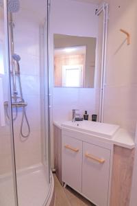 ein weißes Badezimmer mit Dusche und Waschbecken in der Unterkunft Villa Les Figuiers in Tallard