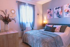 ein Schlafzimmer mit einem Bett und einem Fenster mit blauen Vorhängen in der Unterkunft Villa Les Figuiers in Tallard