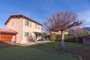 ein großes Haus mit einem Baum im Hof in der Unterkunft Villa Les Figuiers in Tallard