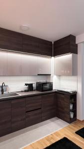 a kitchen with brown cabinets and a sink at Vrdnik Residence - Apartmani Anonim in Vrdnik