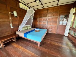 een slaapkamer met een bed in een houten kamer bij Tiger home stay Phayam in Ko Phayam
