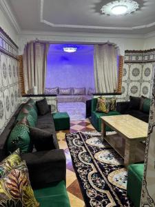 una sala de estar con un sofá y una mesa en Dar Noor El Chams, en Oulad Akkou