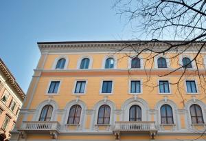 a large yellow building with many windows at House 5 in Trieste