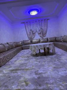 una sala de estar con un sofá y una mesa en Dar Noor El Chams, en Oulad Akkou