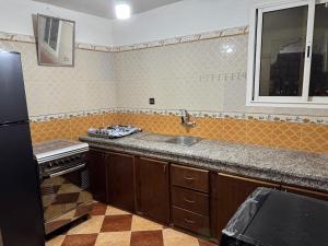 cocina con fregadero y nevera negra en Dar Noor El Chams, en Oulad Akkou