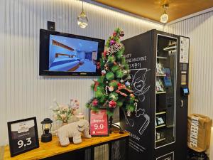 een kerstboom op een tafel met een tv bij Sokcho Ritz Hotel in Sokcho