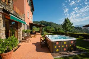 una vasca idromassaggio su un patio accanto a un edificio di Podere Gianpaolo a Pescia