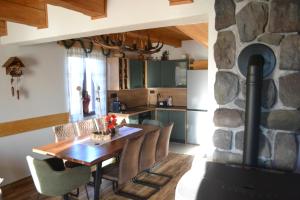 a kitchen with a wooden table and a stone fireplace at Mountain Chalet & Spa Makov Hrib in Makov Hrib