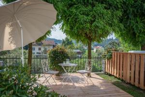a patio with a table and chairs and an umbrella at Apartmaji Hiša kranjske čebele in Višnja Gora